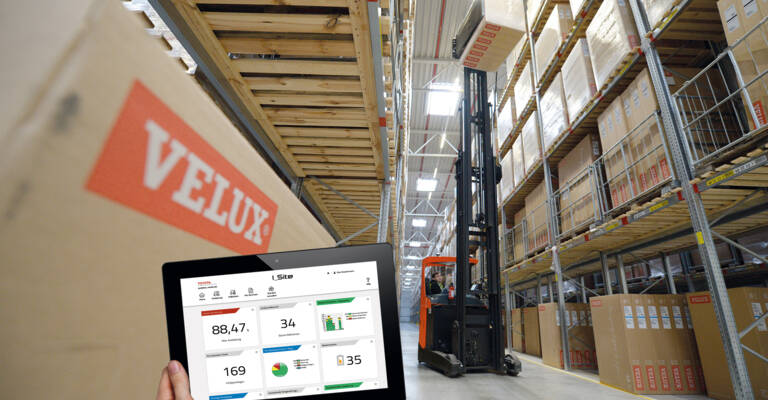 Worker using I_Site fleet management on a tablet, with reach truck in background