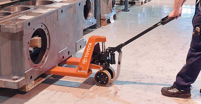 warehouse operator using a toyota hand pallet truck