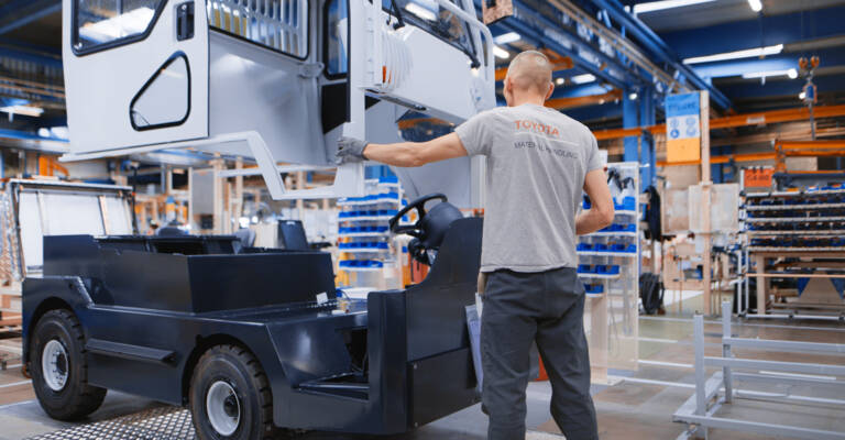 Worker assembling tow tractor cabin at Toyota production