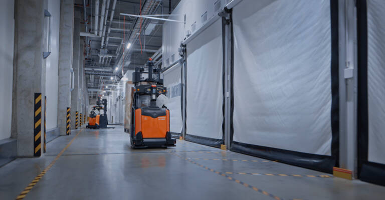 Toyota AGVs moving products around in warehouse corridor